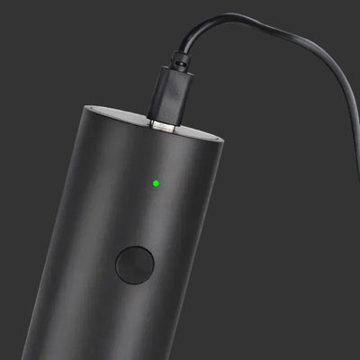 Black electronic device with a green indicator light on a white background