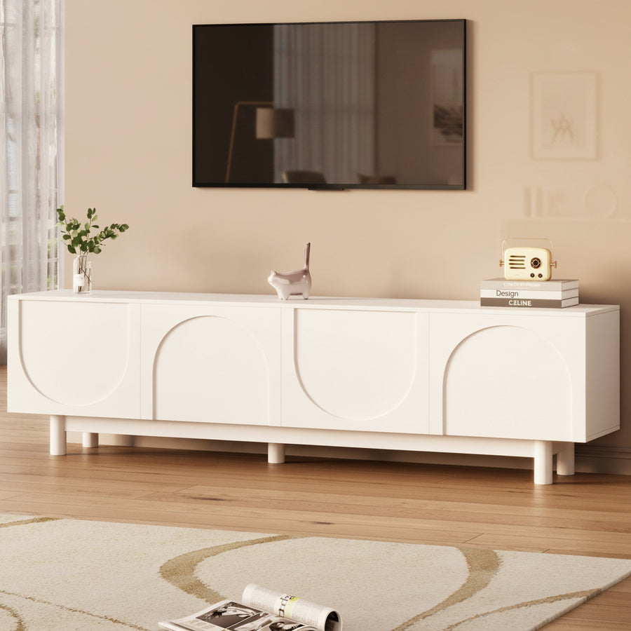 White entertainment console with a TV above it in a room with wooden flooring and a rug.