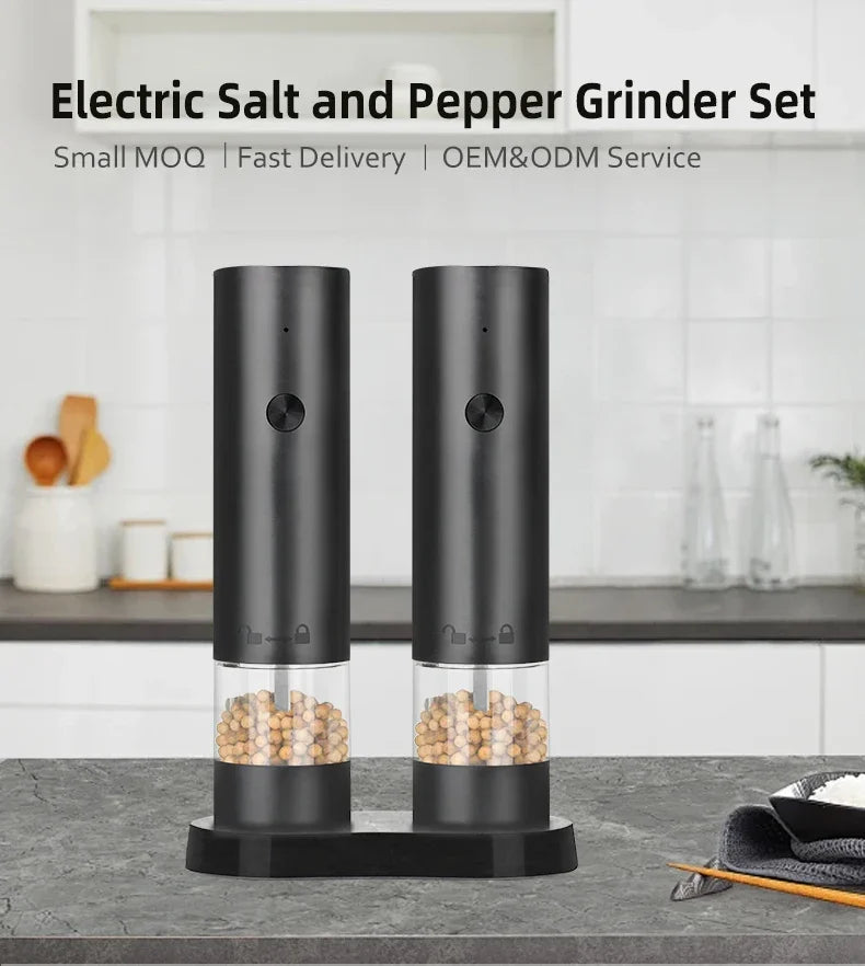 Electric salt and pepper grinder set on a kitchen counter with a white background