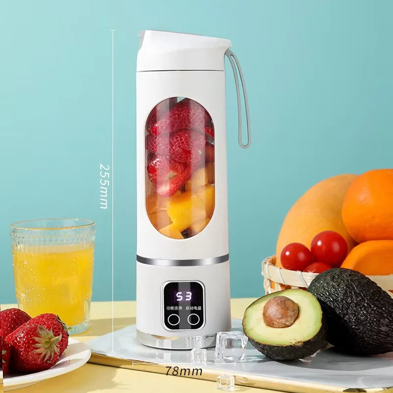 Portable blender with fruits and a glass of juice on a table