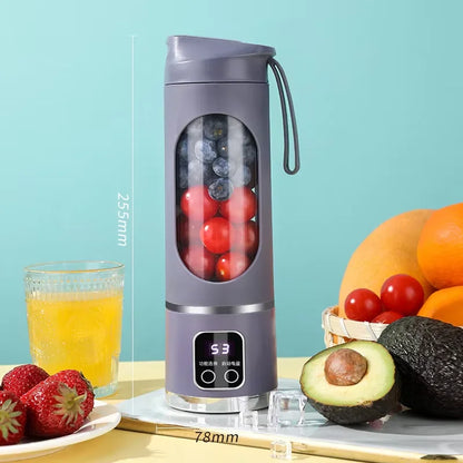 Purple portable blender with fruits and a glass of juice on a light blue background