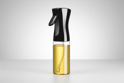 Spray bottle with black nozzle and clear body containing oil, labeled '300ml' on a white background.